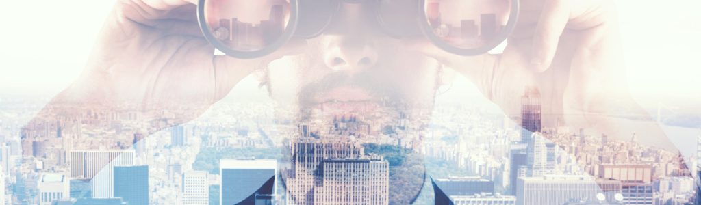 Businessman looks at the city from the roof with binoculars